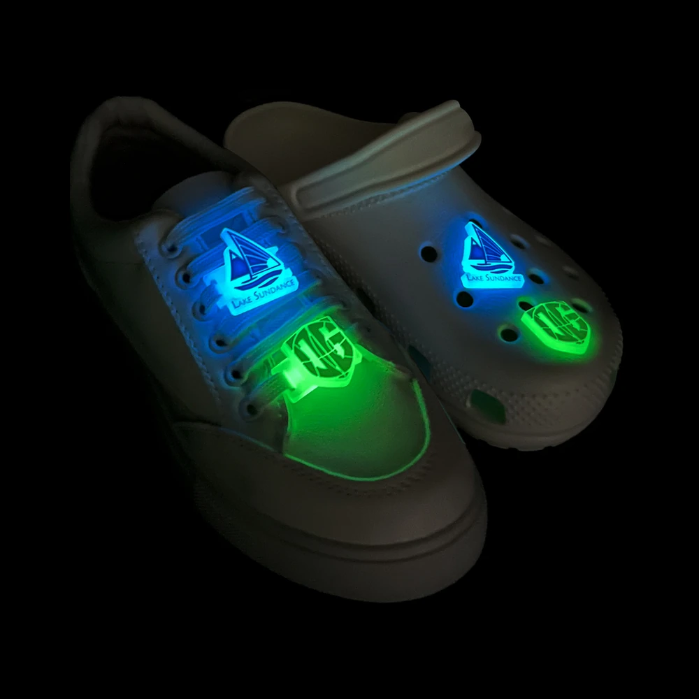 Glow-in-the-dark 2-in-1 clog and shoelace charms – Lake Sundance and shield designs illuminated in the dark