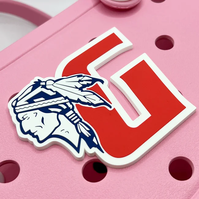 Close-up of a die-cut rubber bag charm with full-color logo