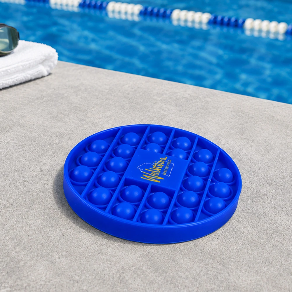 Custom blue silicone pop bubble coaster beside a swimming pool